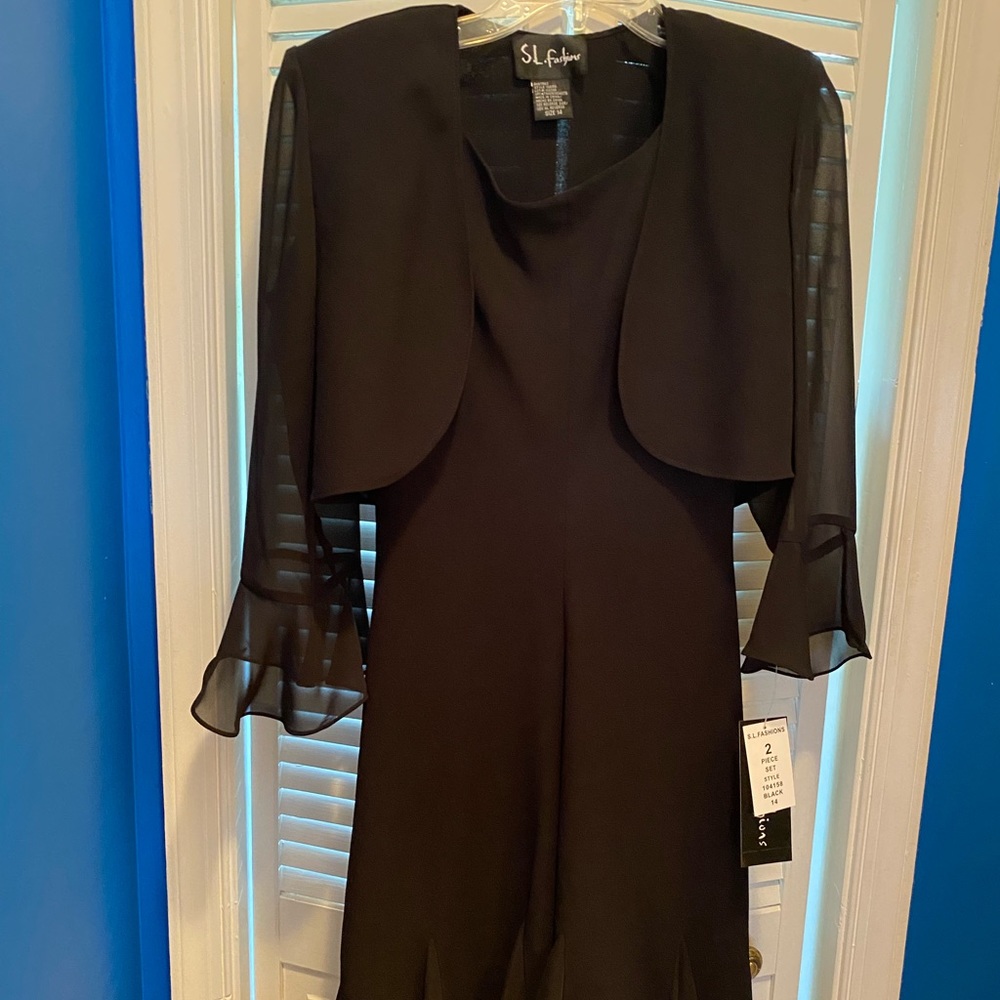 Black dress with sheer sleeved jacket.